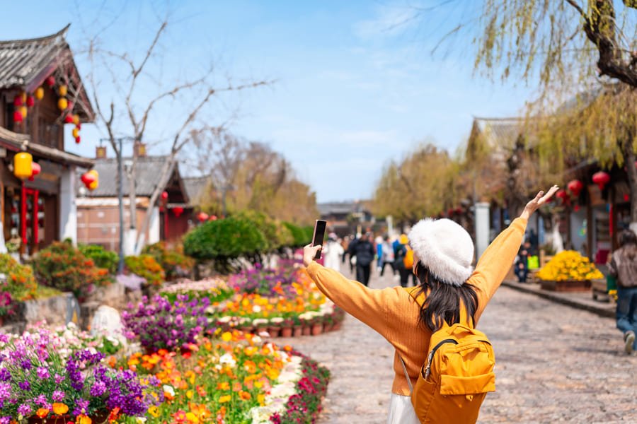 mujer de espaldas con brazos levantados disfrutando Yunnan